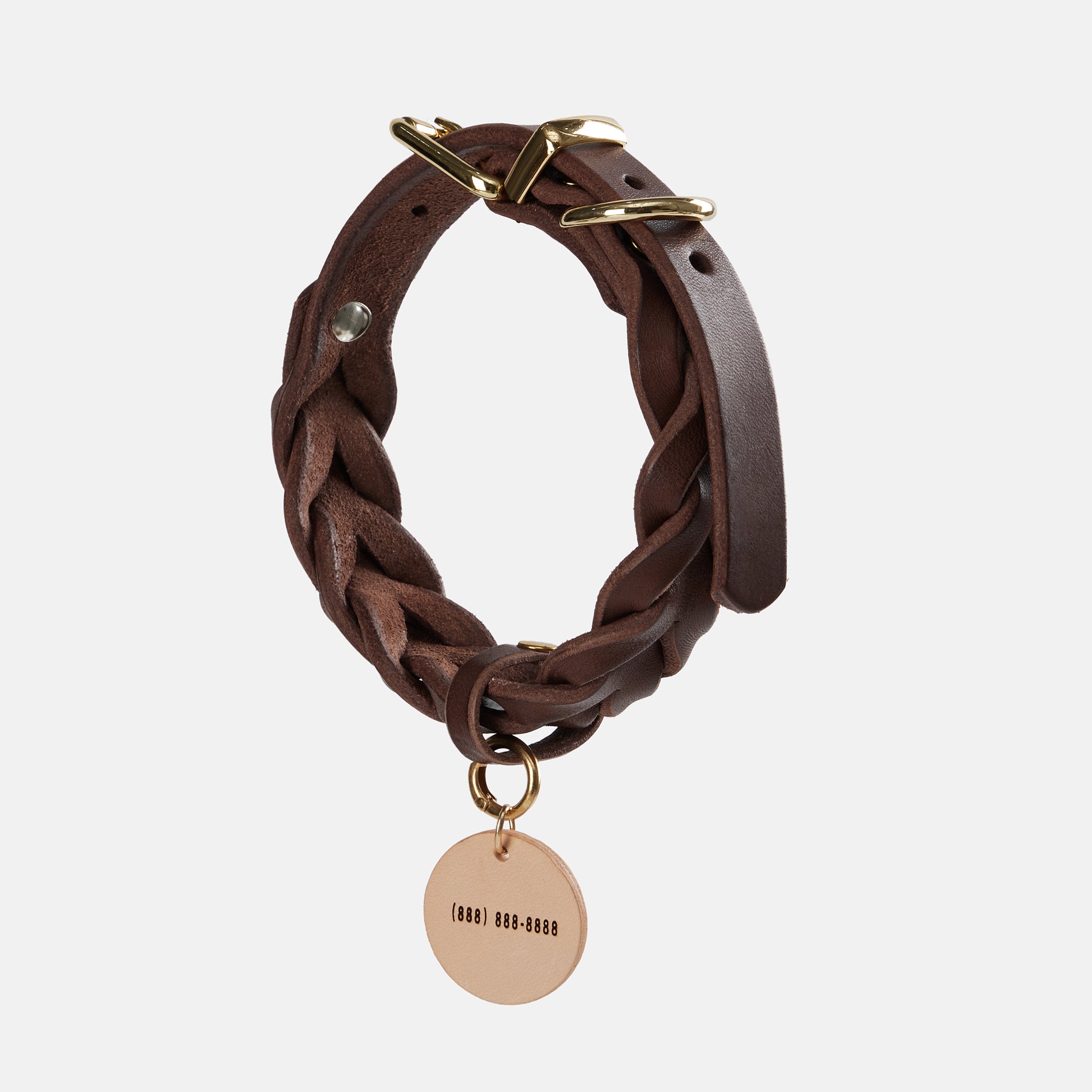 Personalized leather dog tag shown with name detail and natural leather texture.