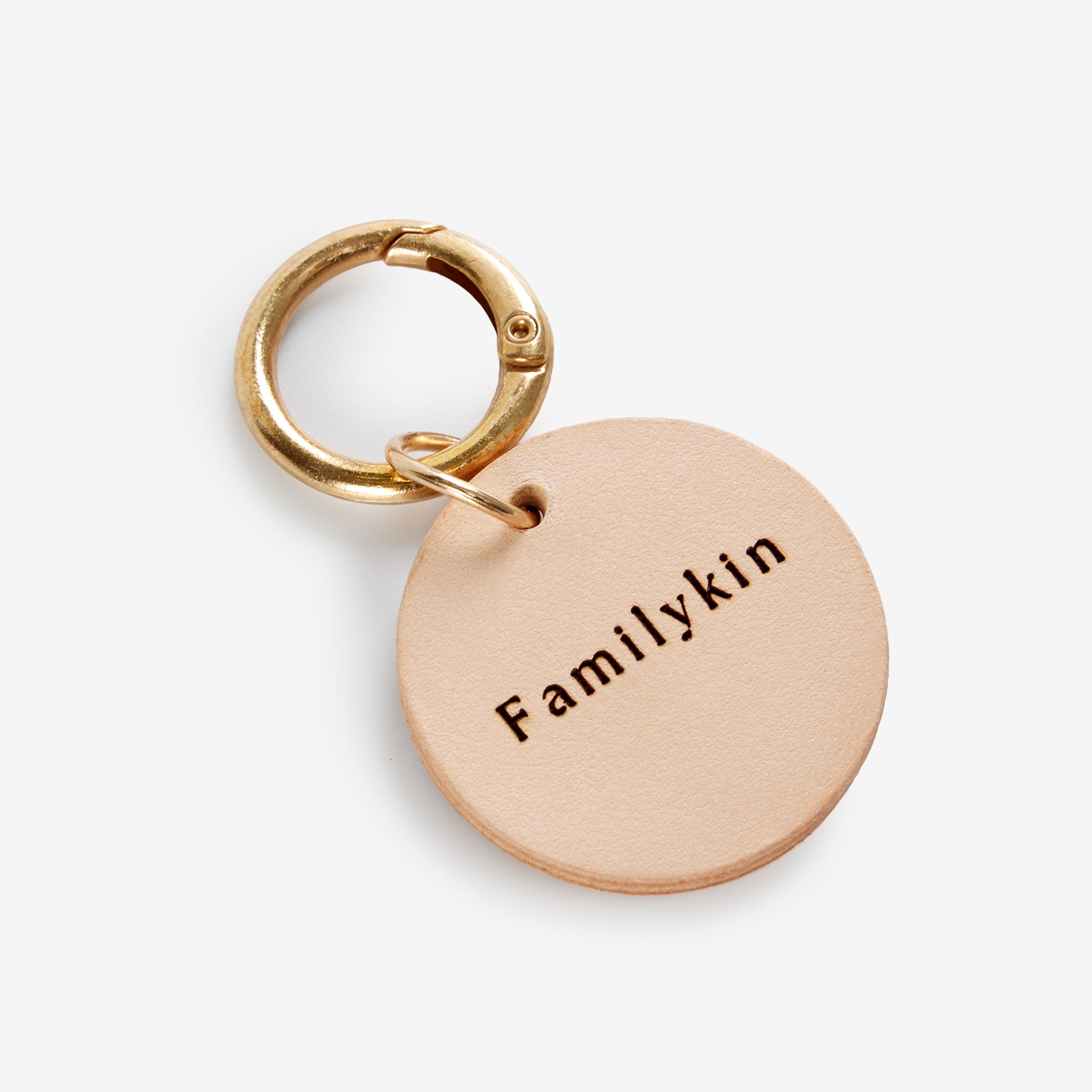 Personalized leather dog tag shown with name detail and natural leather texture.